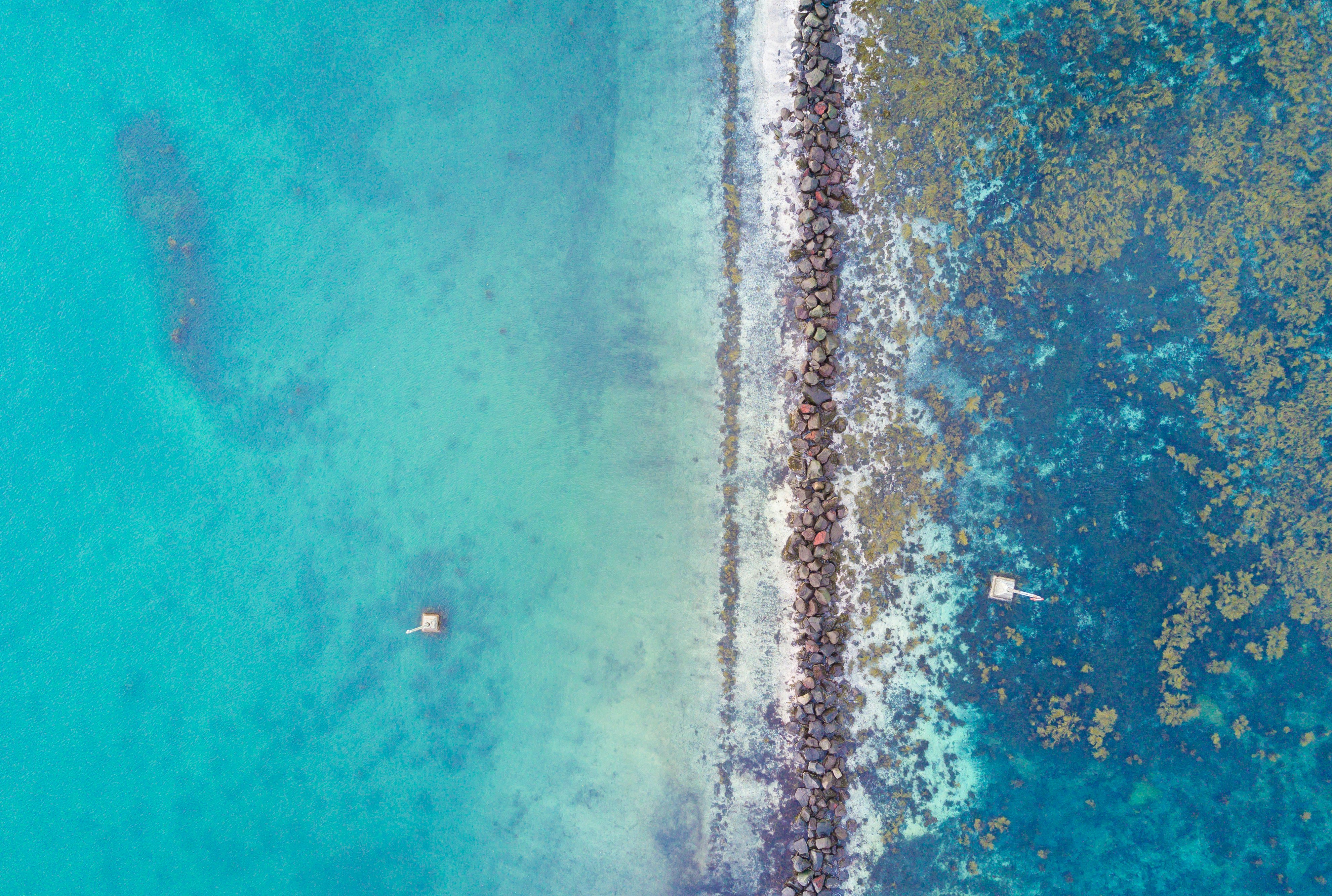 aerial photography of rock beside body of water